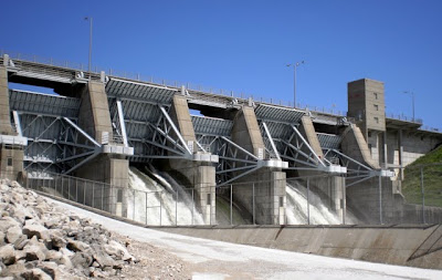 Two of the five tainter gates at the Red Rock dam release water from the reservoir