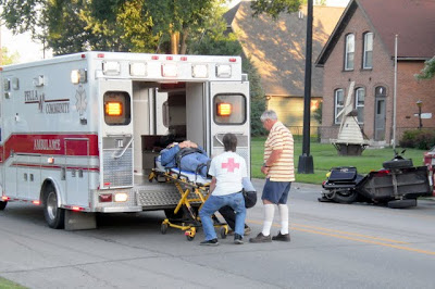 First responders load the driver of a motorcycle into the ambulance