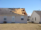 Rear view of the neighbor's house. The white stuff on the roof is insulation. It was in the front lawn of my place too.
