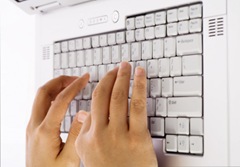 Hands typing on a computer keyboard