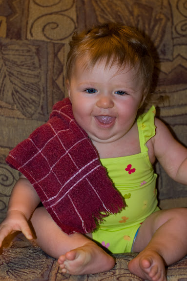 The happy baby has a tea towel to play with.