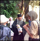 Father Irenaeus, handing out hot pies believers