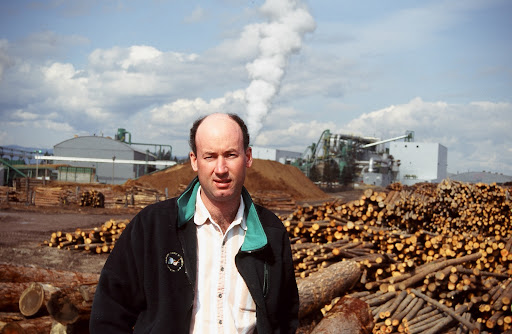 Mike Covey was regional manager for Plum Creek Timber Company when this picture was taken at the company's new medium density fiberboard plant at Columbia Falls, Montana in 1996. Mr. Covey has since moved on and is now chairman, president and chief executive officer of Potlatch Corporation. Potlatch was the Intermountain West's largest vertically integrated forests products company until it sold its manufacturing facilities and became a real estate investment trust. It owns 1.6 million acres of timberland in Idaho, Arkansas, Minnesota and Wisconsin.