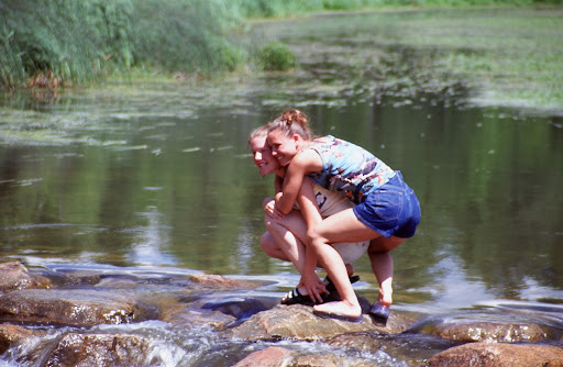 Two young ladies mug for a friend's camera in this 1999 picture taken at the headwaters of the Mississippi River near Lake Itasca, Minnesota. It is possible to literally walk across the Mississippi on the rocks these girls are standing on. Nearby Itasca State Park, established in 1891, is Minnesota's state park. The park's interpretative signs do an excellent job of describing various tree species that grow across the state.