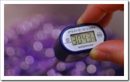 digital thermometer immersed in purple candy syrup and reading 304.3 degrees F