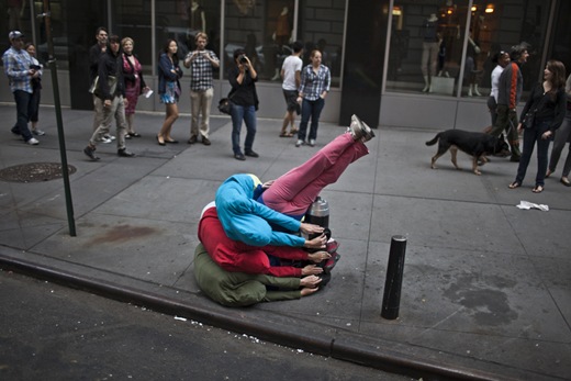 Performers situate themselves into position during a piece entitled "Bodies in Urban Spaces" by choreographer Willi Dorner.  Starting at sunrise, the performers inched their way into different spaces throughout lower Manhattan.<br /><br />CREDIT: Bryan Derballa for The Wall Street Journal<br />NYBODIES