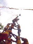 smashing the jug (note liquid falling from jug) After this picture it started pelting rain and I ended up dancing with this dahi handi team! brilliant!