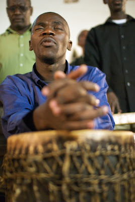 Man praying and holding drum