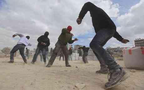 Masked Palestinian demonstrators play stones during clashes with Israeli infantry in the easterly Jerusalem