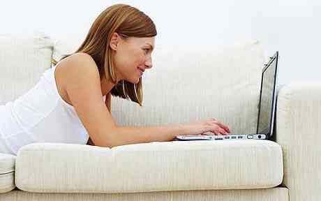 Woman utilizing laptop at home Gordon Brown promises super-fast broadband for each home