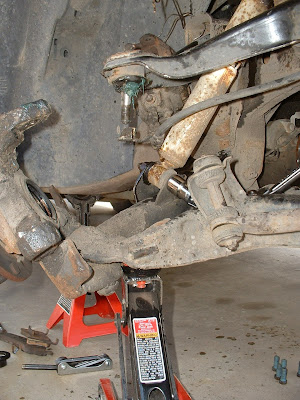 Next, before I removed the bolts for the shock, I placed a jack under the lower control arm.  This is so when the shock is removed, the jack will keep the control arm from being violently pushed down.  If you didnt do this and you pulled the shock out anyway, the whole thing would to POP like a jack-in-the-box.