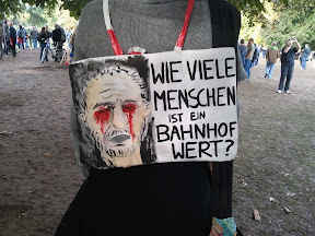 Demonstrant mit Schild "Wie viele Menschen ist der Bahnhof wert?"
