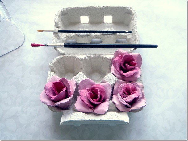 Rosas creadas con hueveras de cartón, colocadas en una huevera.