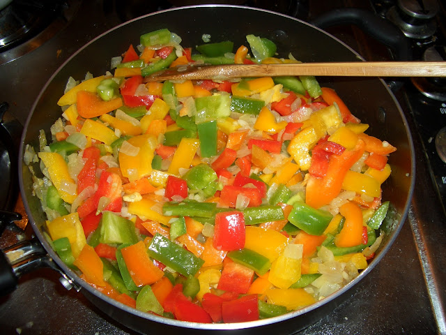 Cut up peppers hit the pan after sauteing the onions and garlic