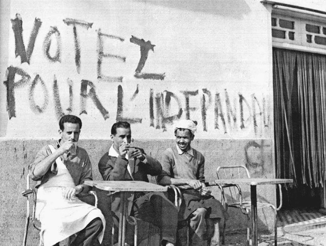 Algerian Independence Campaign. Men in Algiers drink coffee on June 17, 1962, in front of a wall painted with a command to vote for independence in the upcoming referendum. . 