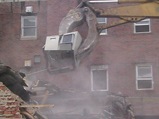 The grapple tears parts of the building away