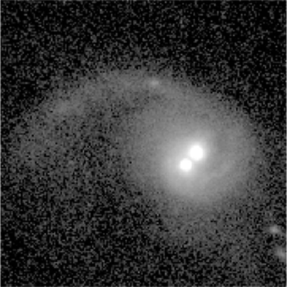 Dos brillantes núcleos activos correspondientes a dos agujeros negros. La cola vista arriba a la izquierda sugiere que este es el resultado de la fusión de dos galaxias. Credit: Dr. Julia Comerford - haz click par ver la imagen a tamaño original Dos brillantes núcleos activos correspondientes a dos agujeros negros. La cola vista arriba a la izquierda sugiere que este es el resultado de la fusión de dos galaxias. Credit: Dr. Julia Comerford