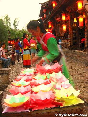 A girl selling mini lantern, one can lit the candle and leave it flow down the small river after making wishes
