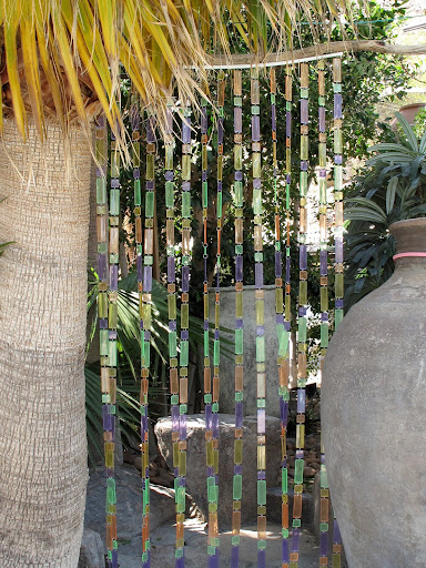 An outdoor shower gets a colorful beaded curtain.