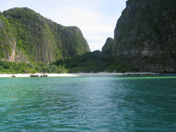a body of water with mountains in the background with Phi Phi Islands in the background