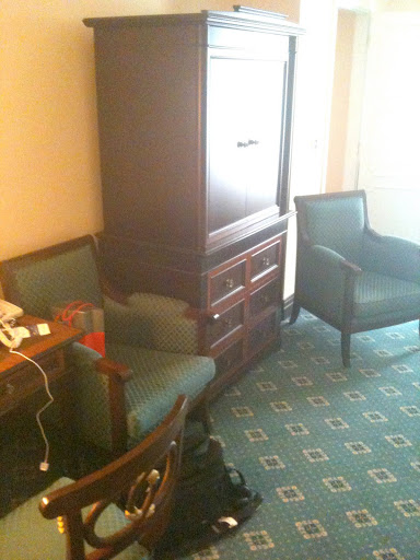 a room with a cabinet and chairs