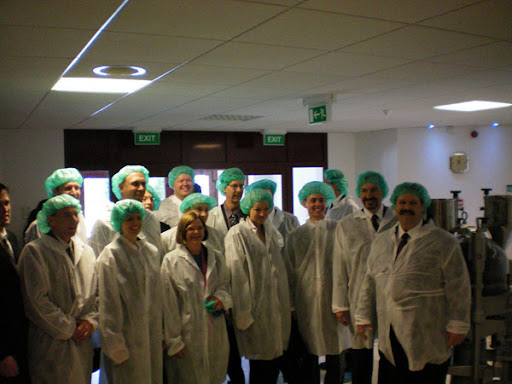 a group of people wearing white coats and green hair nets
