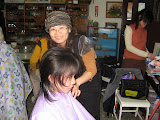 Bi-ling cutting hair at the Home of God's Love