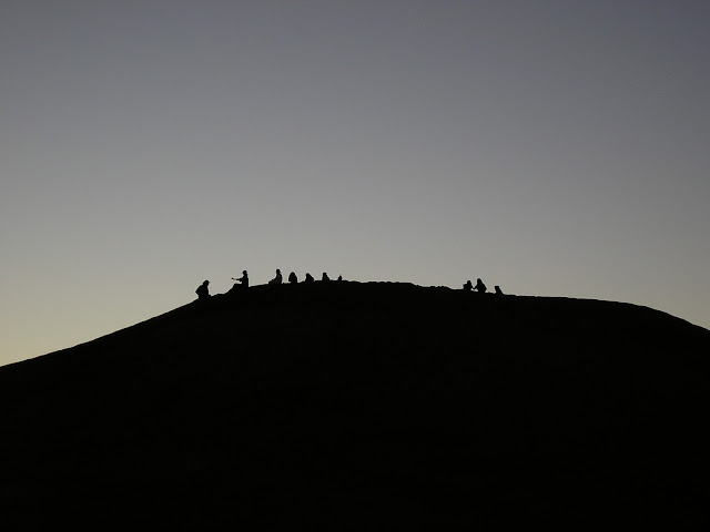 Fellow travelers still on the sand dune at dusk