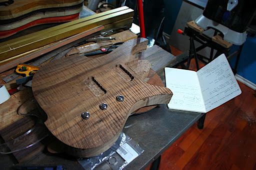 2010.01.21 Update: Pickup and neck cavities roughed out using a Forstner bit on the drill press. These will be cleaned up on the router table. The control recesses were also cut. We prefer a tight, flat-bottomed control recess to hide the bottom of the knob and any chance that the nut and mounting washer for the pot will be seen, making the controls low-profile but still usable. This guitar is getting a 16" radius "arc" top, so the knobs won't be this deep after the carve is done.