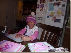 Isabella loves to draw while wearing her winter hat