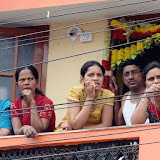 People watch from their home in curfew-bound areas in Hyderabad's old city on Tuesday.