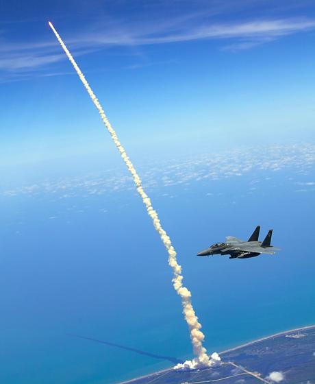Shuttle launch with jet in foreground