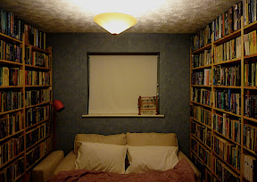 bed surrounded by bookshelves