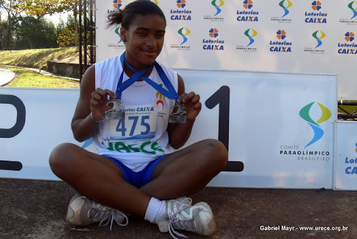 Legenda: Viviane no pódio, segurando duas medalhas de prata