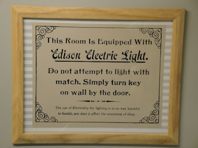 Curiosa advertencia. Dice: Esta habitación está equipada con Luz Eléctrica Edison. No intente encenderla con una cerilla. Simplemente gire la llave que está en la pared al lado de la puerta. El uso de electricidad para alumbrado no es de ninguna manera dañino para la salud y tampoco perturba el sueño