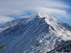 The wind appears to be taken the snow of the north face of that mountain