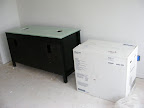 Backside of the bathroom vanity and the toilet in the box