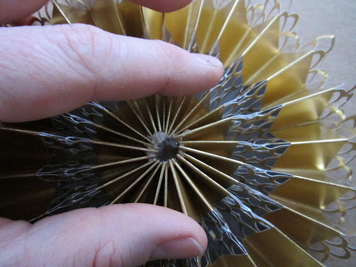 I pushed the upper edges of the folded loop together and downward to create the circular medallion.