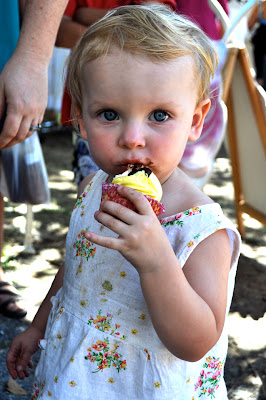 7/11/2010-A young shopper takes a bite of Jacqueline Frasers decorative and delicious cupcakes sold at her Cute as a Cupcake stall near St. Marys Church. edit Delete caption