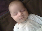 A close up of Audrey sleeping in her overalls.