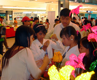 MCCID students Arianne Jane, Jannsen and Maricris inspects one of the flower decoration exhibitors.