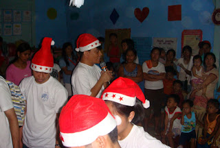Sir Jojo explains to the children and their parents about the purpose of the Share-a-Toy activity.