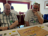 Players during the game of Ra, a thoughtful pose