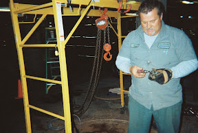 A technician stands in front of the heavy-duty pulley used to remove the old pipes.