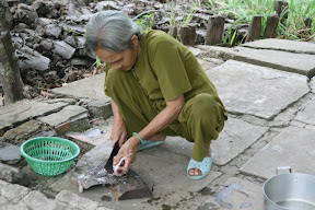 Happily chopping a fish into its component quarks, this lady barely noticed the herd of tourists troop by.