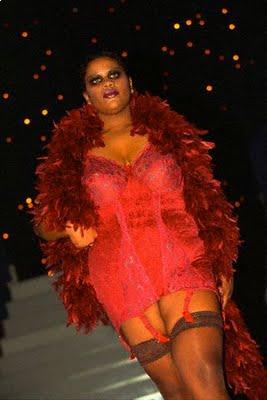 Plus size model wearing a hot pink lace one piece corset and brassiere