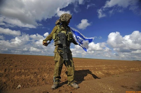 RNPS IMAGES OF THE YEAR 2009 - An Israeli soldier holds the national flag after crossing back into Israel from the Gaza Strip January 18, 2009. Hamas said on Sunday it would cease fire immediately along with other militant groups in the Gaza Strip and give Israel, which already declared a unilateral truce, a week to pull its troops out of the territory.  REUTERS/Amir Cohen (ISRAEL MILITARY CONFLICT)