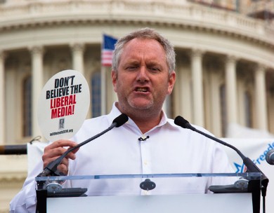 Brietbart with 'DON'T BELIEVE THE LIBERAL MEDIA!' sign