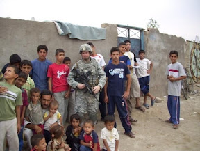 First Lt. Nicholas Griffo, 2nd Platoon leader, “B” Battery, 1st Battalion, 377th Field Artillery Regiment, visits with local children during a patrol in Basrah Province, Iraq. (U.S. Army photo)