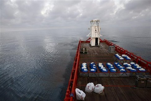 With a sheen of oil as far as the eye can see, the Joe Griffin arrives at the rig explosion site carrying the containment vessel which will be used to try to contain the Deepwater Horizon oil, Thursday, May 6, 2010. AP Photo via sunherald.com